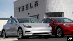 FILE - New 2018 Model 3 vehicles are seen on a Tesla dealer's lot in Littleton, Colorado, April 15, 2018.
