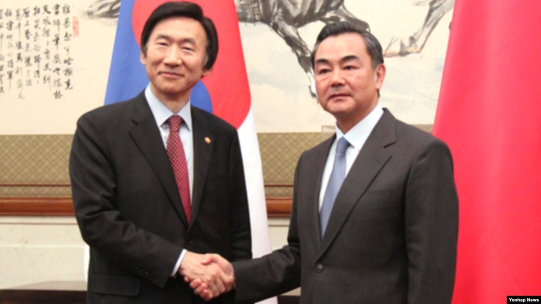 왕이 중국 외교부장(오른쪽)이 지난해 4월 베이징에서 윤병세 한국 외교장관의 회담에 앞서 악수를 나누고 있다. (자료사진)