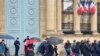 Protesters walk past a pair of police officers in front of the National Assembly, May 19, 2021. (Lisa Bryant/VOA)
