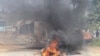 FILE - A barricade is set ablaze in the road during a protest in Mbabane, Eswatini, June 29, 2021. 