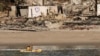 A kayaker goes past a row of homes damaged by the Palisades Fire, Jan. 15, 2025, in Malibu, Calif. 