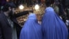 Afghan women shop at a market ahead of the upcoming Eid al-Adha, or the Feast of the Sacrifice in Jalalabad east of Kabul, Afghanistan, October 24, 2012.