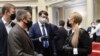 Ukraine's parliament speaker Dmytro Razumkov, center, and former Prime Minister Yulia Tymoshenko, right, wearing face masks to protect against coronavirus talk at an extraordinary parliamentary session in Kyiv, Ukraine, March 30, 2020.