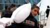 FILE PHOTO: Palestinians gather to receive bags of flour distributed by UNRWA, in Rafah