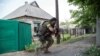 Ukrainian serviceman holds a gun during fighting in Mariinka, in the region of Donetsk, June 4, 2015.