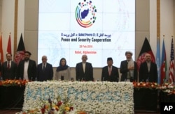 Afghan President Ashraf Ghani, center, and delegates stand for the national anthem during the second Kabul Process conference at the Presidential Palace in Kabul, Feb. 28, 2018.