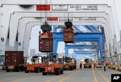 FILE - Containers are unloaded from a ship at the Port of Baltimore, Oct. 24, 2016. The port uses an algae scrubber to remove pollution from the Chesapeake Bay.