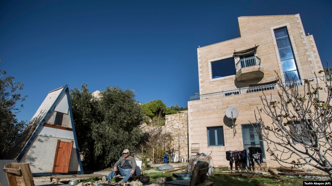 Moshe Gordon sits outside his guest house advertised on the Airbnb international home-sharing site in Nofei Prat settlement in the West Bank.