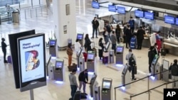 En esta foto del 25 de noviembre del 2020, viajeros esperan para despachar su equipaje para sus vuelos por el feriado de Acción de Gracias en el aeropuerto LaGuardia en Nueva York.