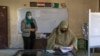 A woman casts her ballot on the first day of the Senate elections inside a polling station in Cairo, Egypt, Aug. 11, 2020.