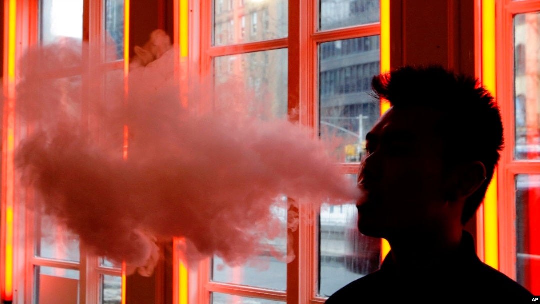 FILE - In this Feb. 20, 2014 file photo, a customer exhales vapor from an e-cigarette at a store in New York. On Friday, Aug. 30, 2019, the Centers for Disease Control and Prevention said they are investigating more cases of a breathing illness associated with vaping.