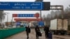 People carrying their belongings cross into to Syria from Turkey through the Kassab crossing on Dec. 27, 2024. 