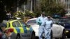 FILE - Forensic officers check for evidence in the street where a heavily pregnant woman was stabbed to death in the Thornton Heath area of London, June 30, 2019. 