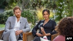 This undated image released March 7, 2021 courtesy of Harpo Productions shows Britain's Prince Harry (L) and his wife Meghan (C), Duchess of Sussex, in a conversation with US television host Oprah Winfrey. - Britain's royal family on March 7, 2021…
