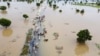 FILE - People walk through floodwaters after heavy rainfall in Hadeja, Nigeria, Monday, Sept 19, 2022.