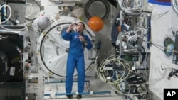 En esta imagen de un video puesto a disposición por la NASA, la astronauta Nicole Mann muestra su atrapasueños durante una entrevista el 19 de octubre de 2022, el primer día de su misión de cinco meses. Mann es la primera mujer nativa americana en el espacio. (NASA vía AP)