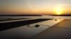 FILE - This aerial photo taken on February 22, 2022 shows floating solar panels for the Sirindhorn Dam hydro-solar farm run by the Electricity Generating Authority of Thailand (EGAT) as the sun sets in Ubon Ratchathani.