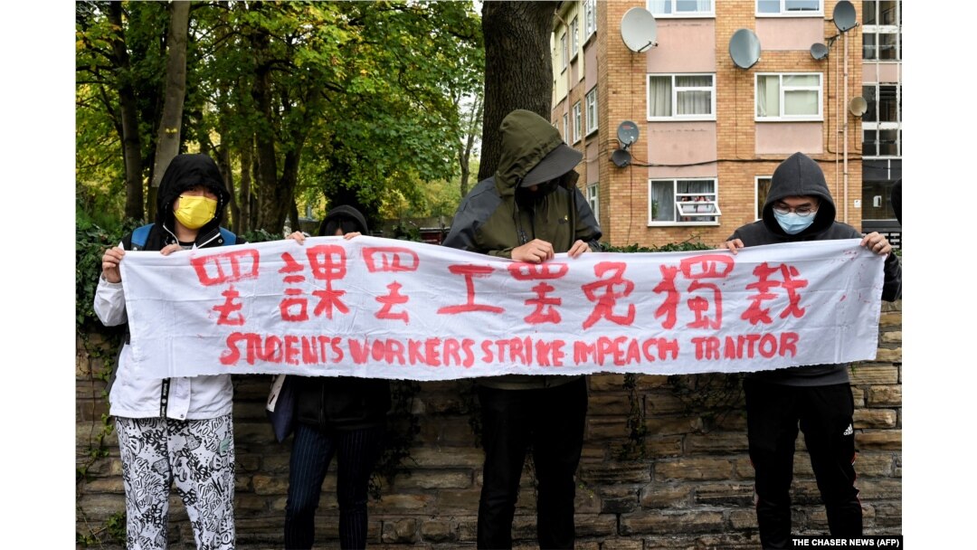 示威者在中國駐曼徹斯特領事館外手持北京四通橋懸掛反習標語的橫幅舉行抗議。(2022年10月16日)