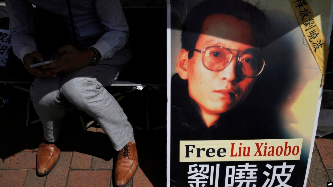 A protester displays a portrait of jailed Chinese Nobel Peace laureate Liu Xiaobo during a demonstration outside the Chinese liaison office in Hong Kong, July 11, 2017.