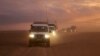 This photo released by the Syrian Arab Red Crescent, shows a convoy of vehicles of the Syrian Arab Red Crescent driving in the Syrian desert heading to Rukban camp between the Jordan and Syria borders, Nov. 4, 2018.