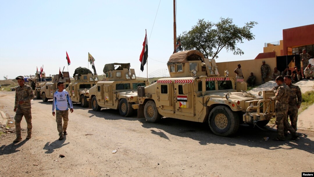 Military vehicles of Iraqi security forces and Shi'ite fighters are seen as they gather at Udhaim dam, north of Baghdad, March 1, 2015. 