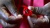 A Kenyan woman prepares ribbons ahead of World Aids Day at Beacon of Hope centre, a non-government organization formed to address women's problem of HIV/AIDS in Nairobi, November 25, 2004.