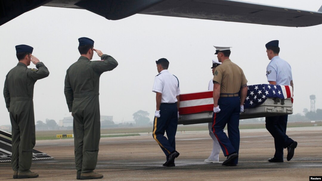 FILE - Pilots salute as U.S. soldiers carry a casket containing human remains, believed to belong to a U.S. servicemen missing in action during the Vietnam War, during a repatriation ceremony at Noi Bai airport in Hanoi, November 2012.