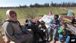 Hassana Abu Firasl, left, a Syrian woman who fled from the Syrian town of Qusair near Homs, is seen with her family at the Lebanese-Syrian border village of Qaa, eastern Lebanon, Monday, March 5, 2012.