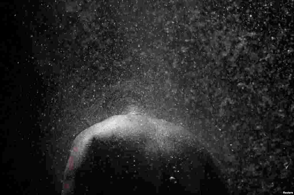 A Haitian man bathes during the celebration of the annual pilgrimage to the waterfall in Saut D'Eau, July 14, 2019.