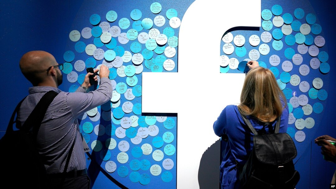 FILE - People stick notes on a Facebook logo at a Facebook developer conference, in San Jose, California, April 30, 2019. 