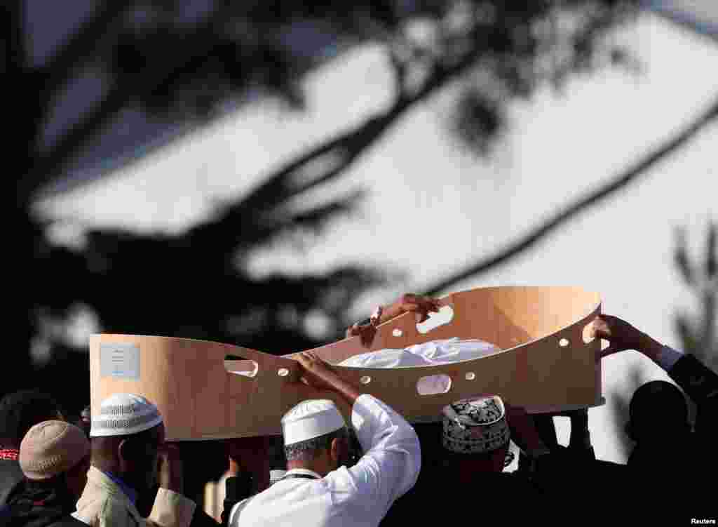 People carry a body during a burial ceremony for victims of the March 15, 2019 mosque attacks, at the Memorial Park Cemetery in Christchurch, New Zealand.