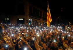 FILE - Demonstrators light their mobile phones during a protest in Barcelona, Spain, Oct. 19, 2019.