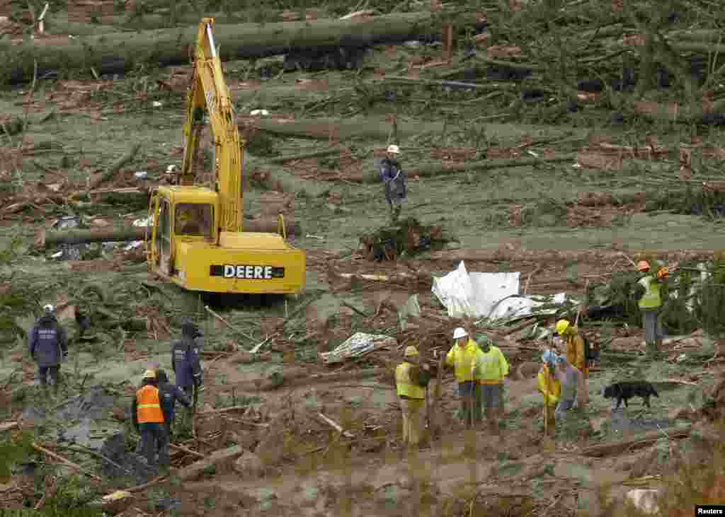 An excavator is used as search work continues in the mud and debris from a massive mudslide that struck Oso near Darrington, Washington, March 27, 2014.