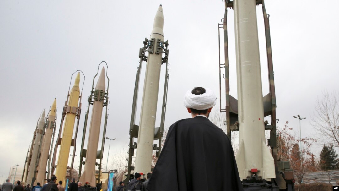 FILE - An Iranian clergyman looks at domestically built surface-to-surface missiles displayed by the Revolutionary Guard in a military show marking the 40th anniversary of the Islamic Revolution, at Imam Khomeini Grand Mosque in Tehran, Iran, Feb. 3, 2019