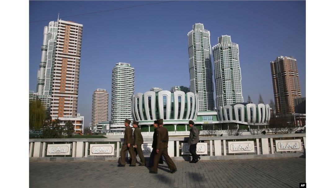 North Koreans walk past Ryomyong Street, the newest residential development in Pyongyang, North Korea, April 11, 2017. North Korean Premier Pak Pong Ju told the Supreme People's Assembly that a priority for the Cabinet this year would be improving the country's standard of living.