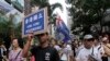 FILE - Protesters hold placards and wave colonial-era flags at an annual pro-democracy rally in Hong Kong, July 1, 2016. As the territory prepares for legislative elections, a new pledge of loyalty to China candidates are required to sign is creating friction.