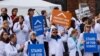 FILE - Researchers and supporters hold signs at a rally during the American Geophysical Union meeting in San Francisco, California, Dec., 2016.