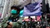 在中國共產黨建立政權週年紀念日，一名警察在香港銅鑼灣打出警告旗。 (2020年10月1日)