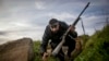 A Syrian insurgent dashes for cover as rebel forces take control of a Syrian Arab Republic military academy in Aleppo in December 2012. 