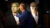 A journalist points at a portrait of U.S. President-elect Donald Trump, with a portrait of Russian President Vladimir Putin at right, during a live telecast of the U.S. presidential election in the Union Jack pub in Moscow, Russia, Nov. 9, 2016. 