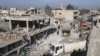 FILE - Residents inspect damage at a site hit by one of three explosive trucks in the town of Tel Tamer, Syria, Dec. 11, 2015. 