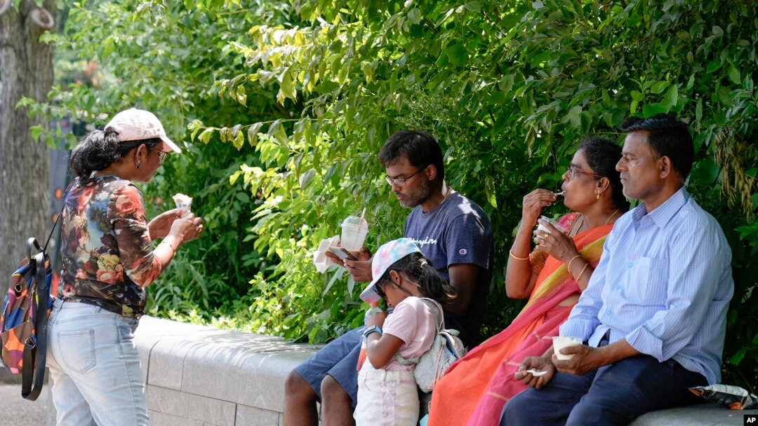 Una familia se refresca con helados en el National Mall, cerca de El Capitolio, el viernes 5 de julio de 2024, en Washington.