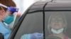 FILE PHOTO: A medical worker swabs a member of the public at a drive-through COVID-19 testing centre in Sydney