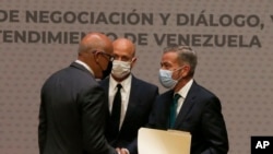 Delegados de oposición y gobierno se estrechan la mano, luego de firmar memorando de entendimiento en agosto de 2021