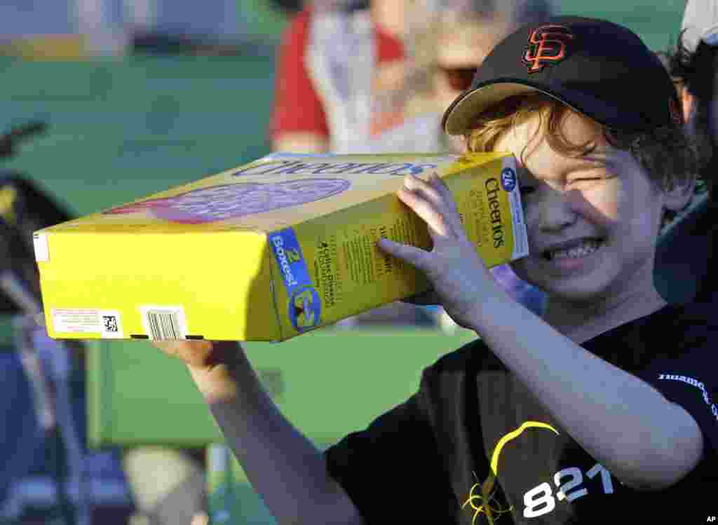 Griffin O'Roak watches the rising sun with his homemade eclipse viewer at a gathering of eclipse viewers in Salem, Ore., Monday, Aug. 21, 2017. (AP Photo/Don Ryan)