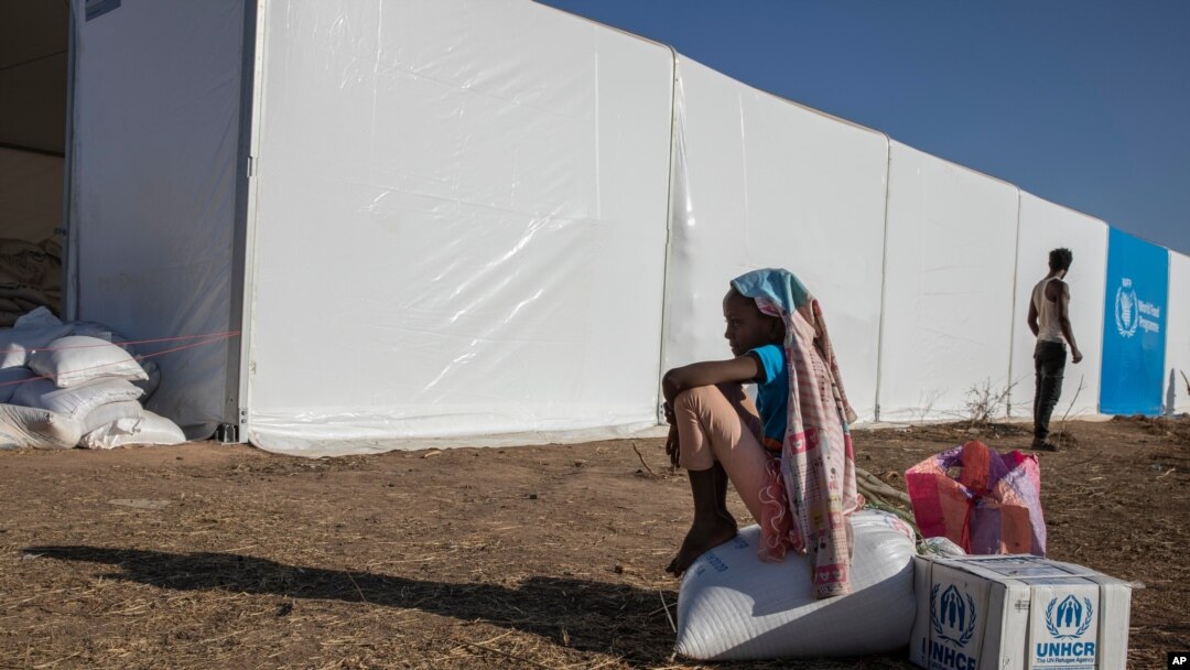 Una niña refugiada de Tigray que huyó del conflicto en la región de Tigray en Etiopía, sentada sobre la ayuda que recibió del ACNUR y el PMA en el campamento de refugiados de Umm Rakouba en Qadarif, este de Sudán, el 24 de noviembre de 2020.