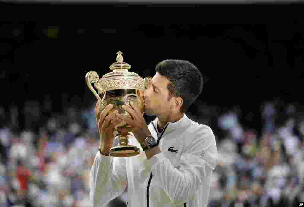 Serbia's Novak Djokovic kisses the trophy after defeating Switzerland's Roger Federer in the men's singles final match of the Wimbledon Tennis Championships in London, July 14, 2019.
