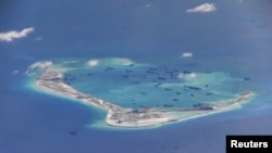 FILE - Chinese dredging vessels are purportedly seen the waters around Mischief Reef in the disputed Spratly Islands in the South China Sea in this video image taken by a P-8A Poseidon surveillance aircraft provided by the U.S. Navy, May 21, 2015. 