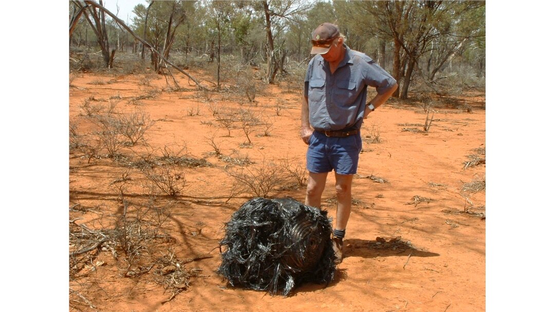 Australian farmer James Stirton stands next to a ball of twisted metal, purported to be fallen space junk, on his farm in southwestern Queensland in this undated handout photograph received March 28, 2008.