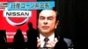 FILE - Passersby are silhouetted as a huge street monitor broadcasts news reporting ousted Nissan Motor chairman Carlos Ghosn's indictment and re-arrest in Tokyo, Japan, Dec. 10, 2018.